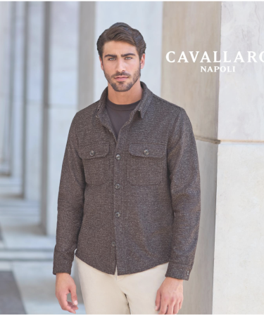 Man draagt een groene Profuomo half-zip trui en kijkt opzij terwijl hij naast een boom staat.