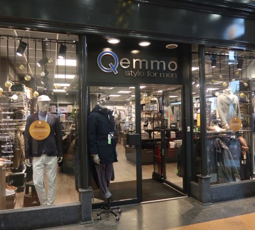 Winkelpui van Qemmo Style for Men in Veenendaal met moderne glazen gevel, mannequins in stijlvolle herenoutfits. Merken zoals Tommy Hilfiger, Strellson en Pierre Cardin zichtbaar in de etalage