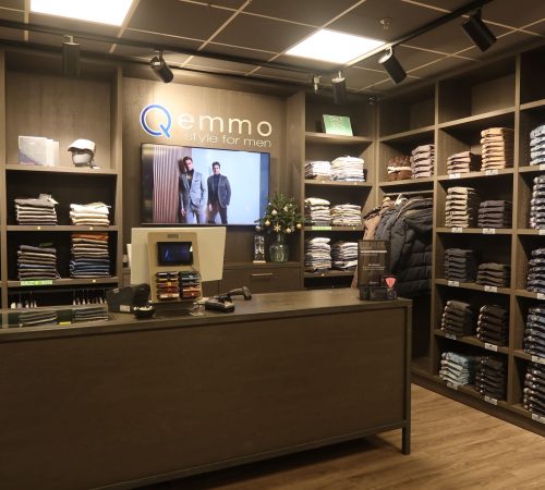 De kassa en servicebalie van Qemmo met moderne afwerking en overzichtelijke presentatie.